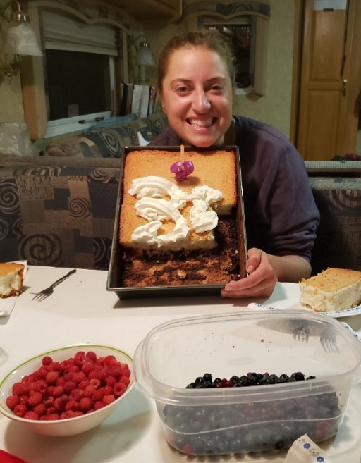 smiling field tech holding up a half eaten cake
