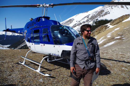 Terry Larsen, on a mountain, in front of a helicopter.