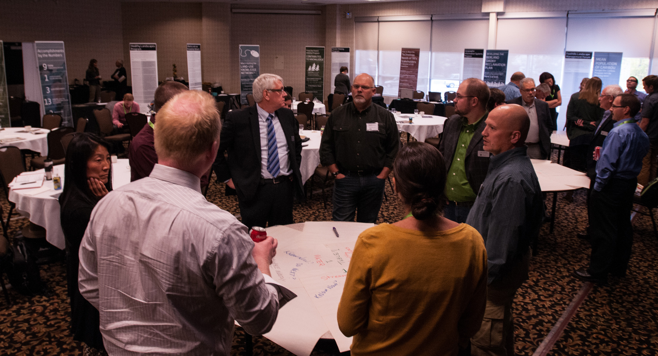 A group of attendees from the 2013 fRI Research Forum gather around a table.