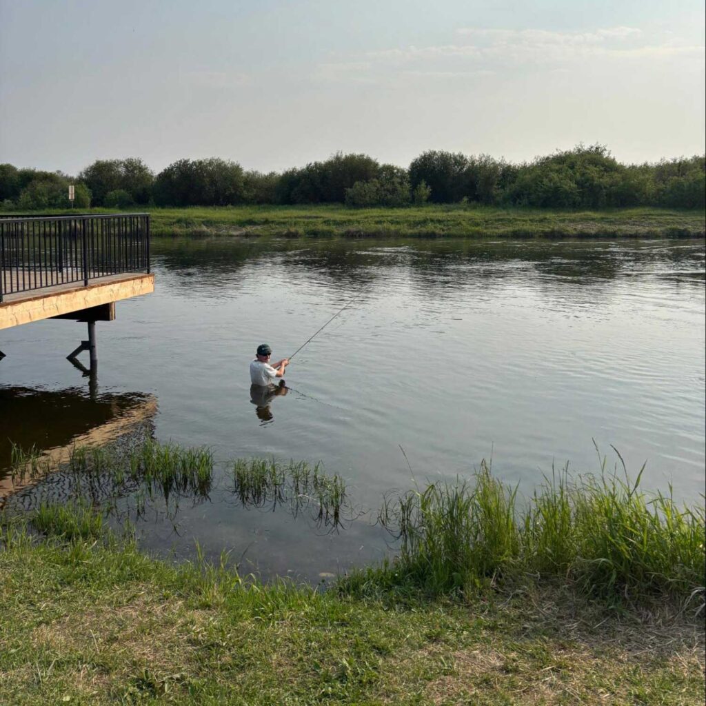 a field tech sits in a river by a water deck fishing photo: javier puac
