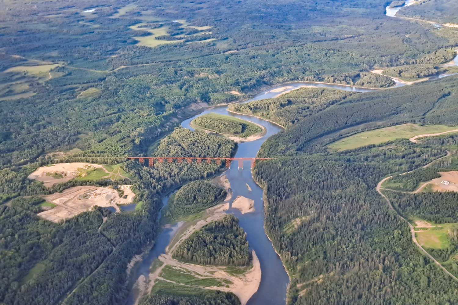 aerial image of a landscape with a large river and many human uses. photo by darío fernánez-bellon